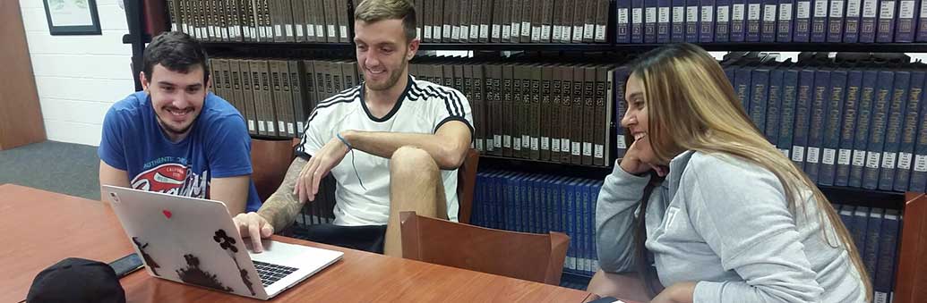 Business students working on a project together in the Thomas University library