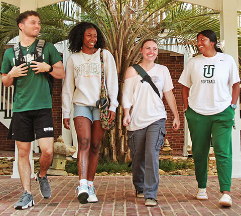 Four Thomas University students walking